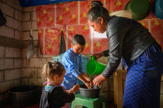 niños con agua lavando sus manos